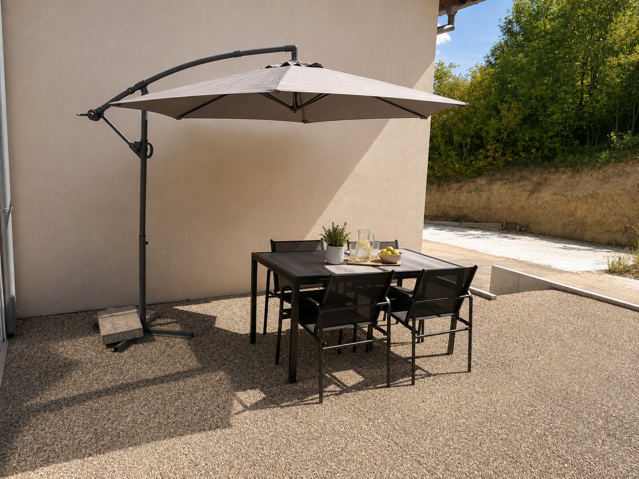 La terrasse de plain-pied de l'Appartement du Bas, meublée sous son parasol