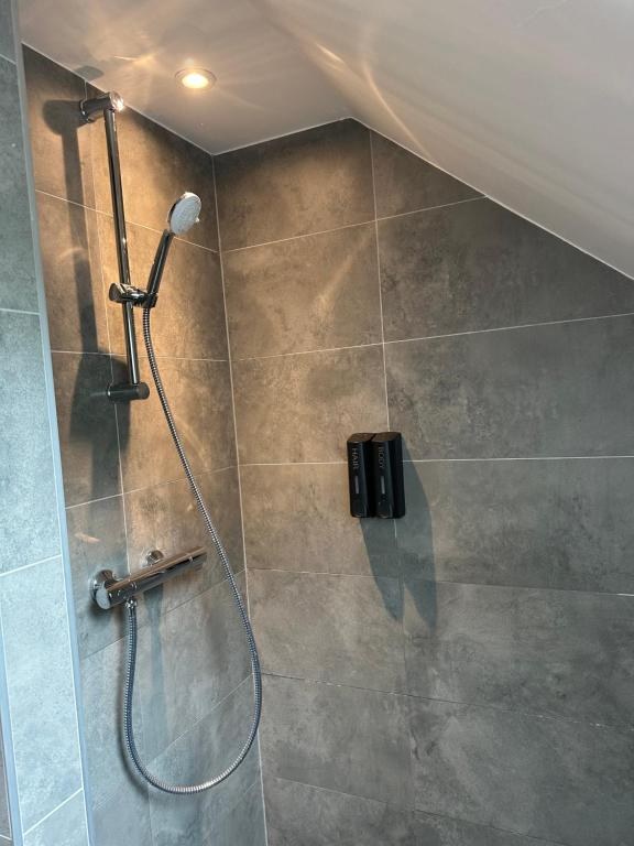 Détail de la robinetterie de la douche et de son distributeur mural