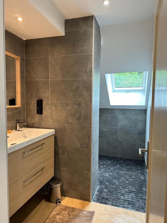 Douche à l'italienne de plain-pied, sol en mosaïque, sous un velux