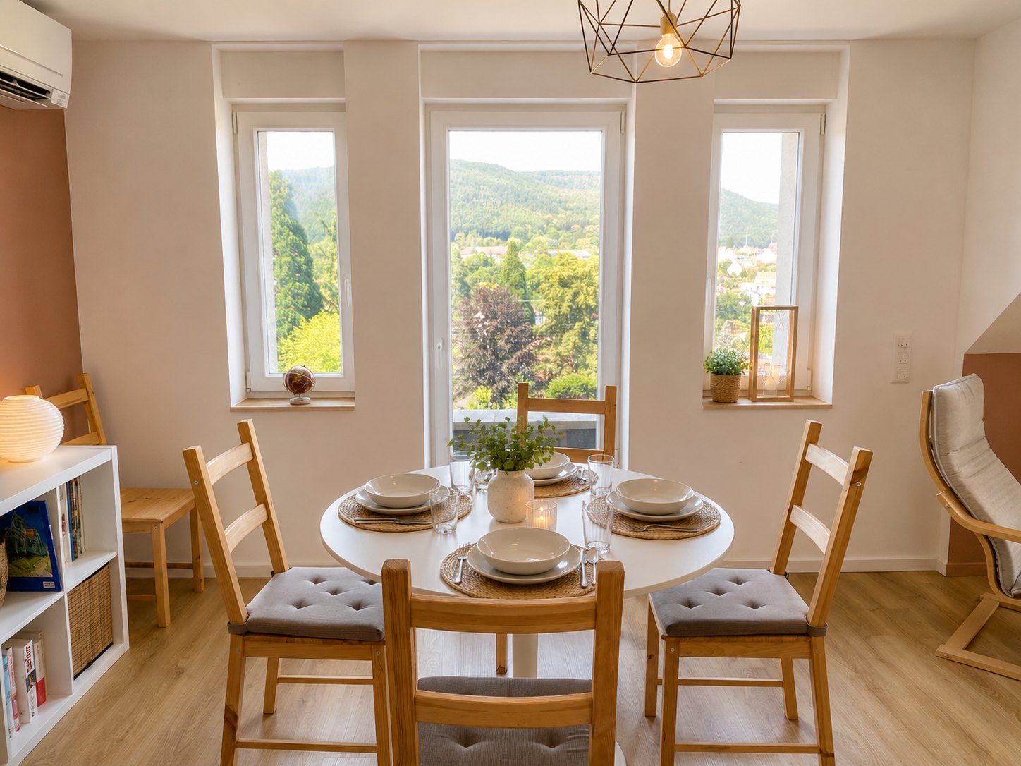 Dining area of the upper apartment, with three windows looking out onto the hills